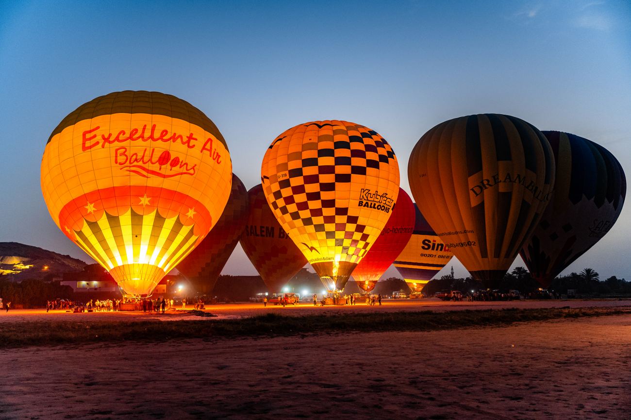 Hot-air balloons glowing at dawn over Luxor