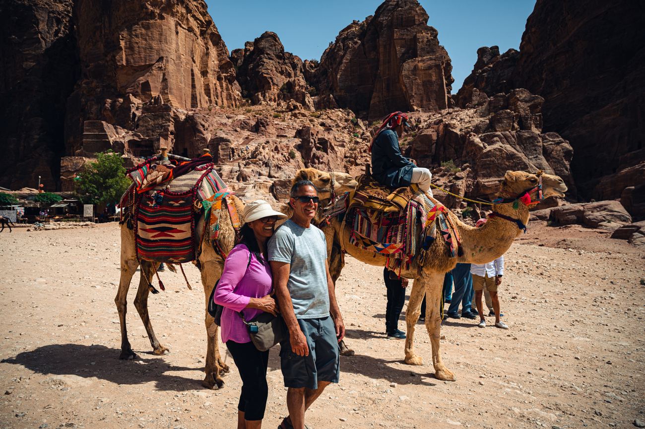 Camels resting before the carved sandstone cliffs of Petra